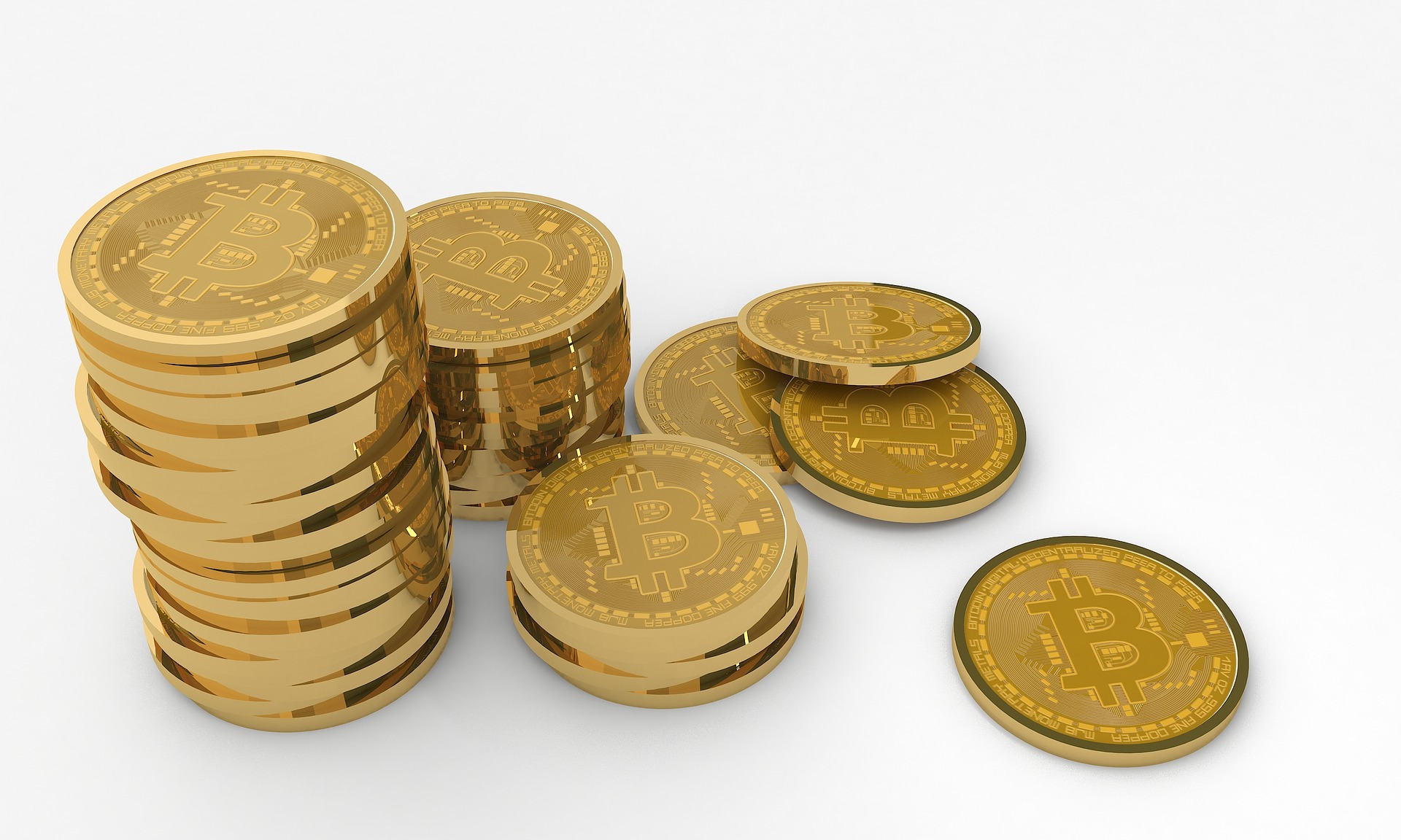 Stacks of gold Bitcoin coins of different heights on a clean white background